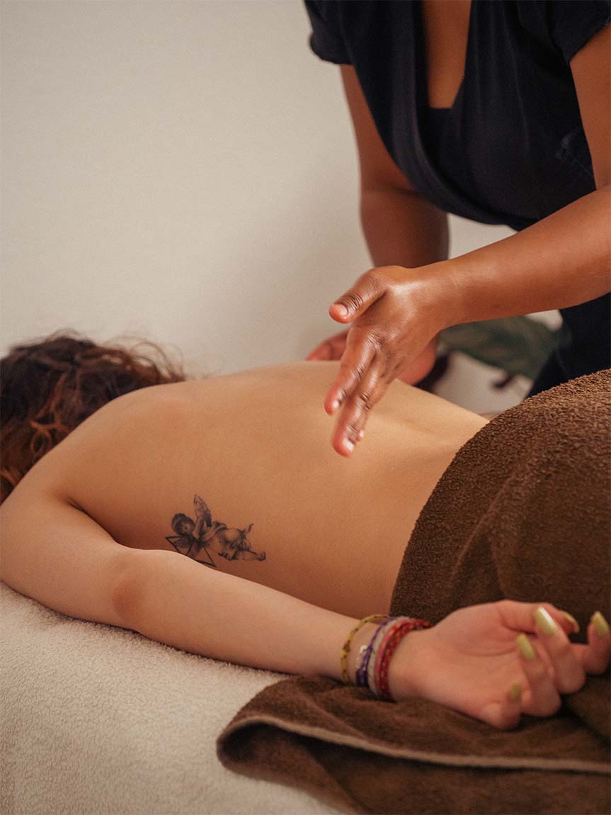 La masseuse effectue des percussions sur le dos de la cliente pour libérer les tensions musculaires